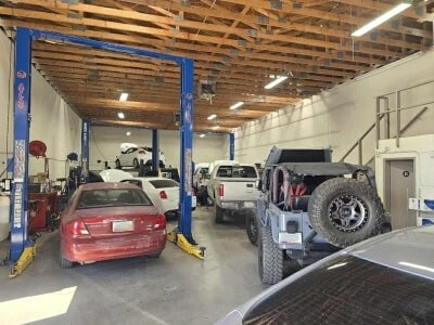 Inside the Mobile Man Auto Repair shop with cars and a truck up on lifts in the service bays