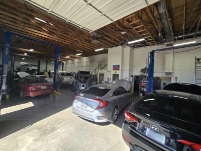 A busy Mobile Man service bay with several cars in for maintenance and repair